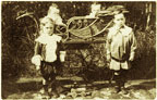 Photograph of young children with a pram.