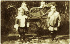 Photograph of young children with a pram. 