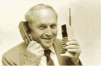 Photograph of a man holding an old and a new mobile phone.